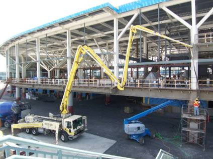 Boom pump feeding an elevated concourse slab on a commercial build