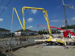 Reaching over water to place pier footings from the shoreline