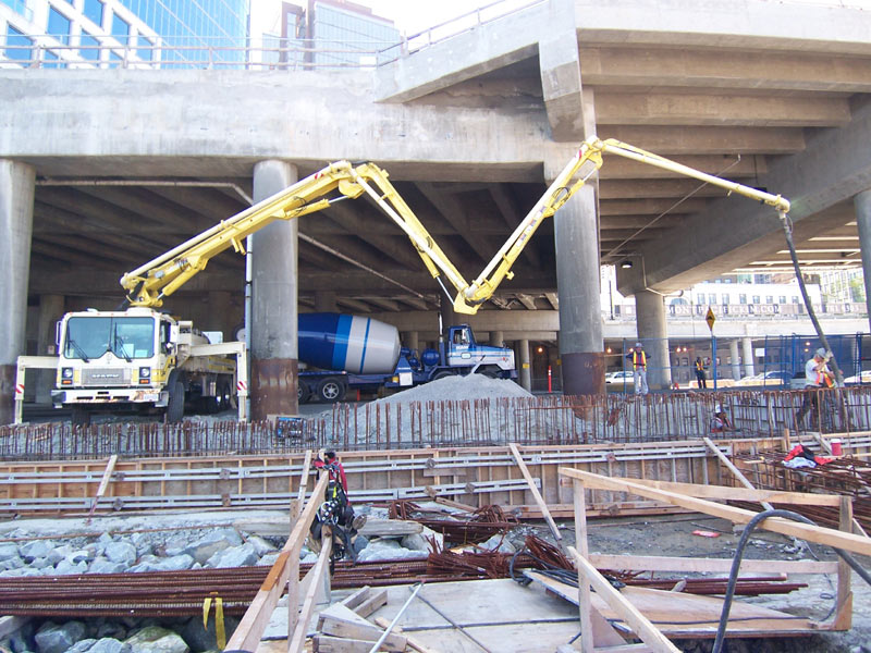 Twin boom pumps placing a deck beneath an elevated viaduct, downtown Vancouver