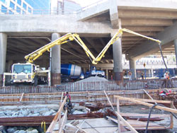 Twin boom pumps placing a deck beneath an elevated viaduct, downtown Vancouver