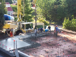 Crew screeding and levelling a residential slab straight off the boom